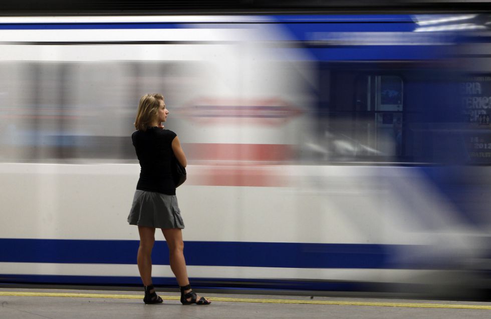 Una mujer observa un tren de metro al entrar en la estación. / ULY MARTÍN